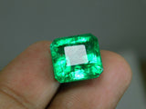 Slightly zoomed-out image of the emerald in hand, offering a full view of its shape and proportions.