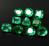 Emerald gemstones mixed shapes on black backgroundc