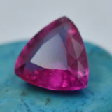 Trillion Shaped Pink Ruby 9.35 Ct Placed on Blue Surface – Natural Mozambique Gemstone with Excellent Cut