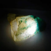 Mineral sample with green and white colors on a dark background