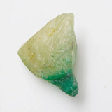 Geometric stone with green and beige colors on a white background