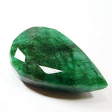 Pear-shaped emerald gemstone on white background