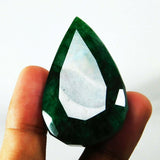 Emerald gemstone held upright between two fingers