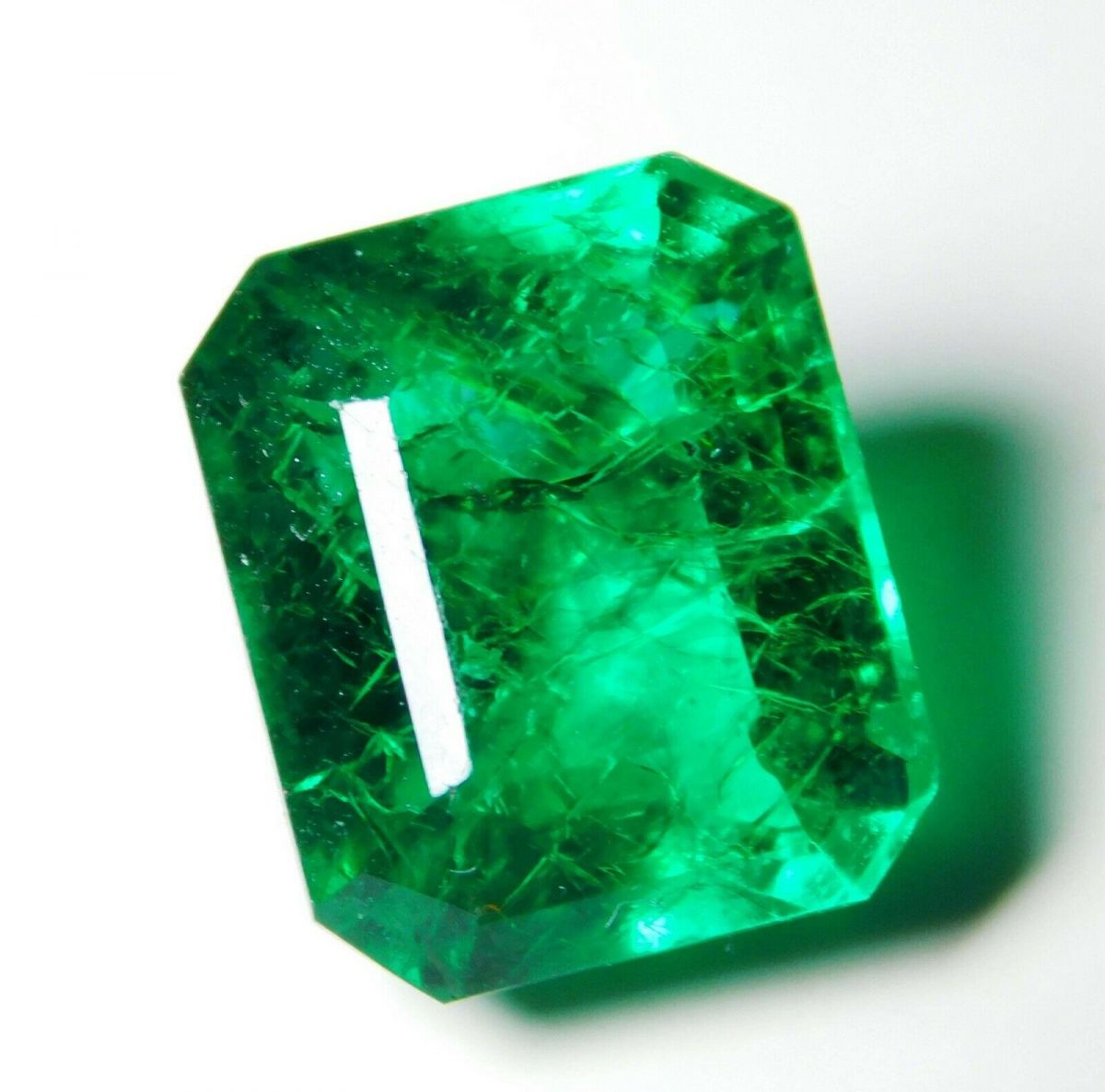 Emerald-cut Muzo Colombian emerald placed on white background