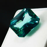Loose certified grandidierite, 12.56 ct emerald cut bluish-green natural gemstone.