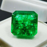 Certified natural Colombian emerald of 7 carats placed in a white display box, highlighting its vivid green color and excellent emerald cut.