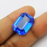 Certified Blue Tanzanite 17.60 Carat Emerald Cut Gemstone Held Between Scissors