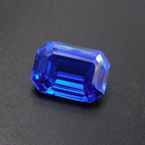 Natural Eye Clean Blue Tanzanite Emerald Cut Gemstone 17.60 Ct on Grey Background