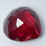 Eye-clean 8.65 Ct pear-shaped red ruby placed flat on white surface – certified loose gemstone