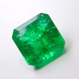 Certified Colombian emerald gemstone centered over a clean white background, highlighting its emerald cut and vivid green tone.