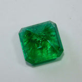 Backward view of the emerald on a white surface, showing the base structure and depth of the gemstone.