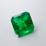 Angled view of the emerald under soft lighting, showcasing its clarity and expertly faceted edges.