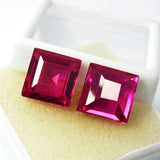 Top view of eye-clean pink rubies with excellent square cut on white foam box – natural gemstone pair