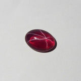 Tilted view of oval red star ruby with six-ray asterism – 9.65 Ct certified gemstone on white background