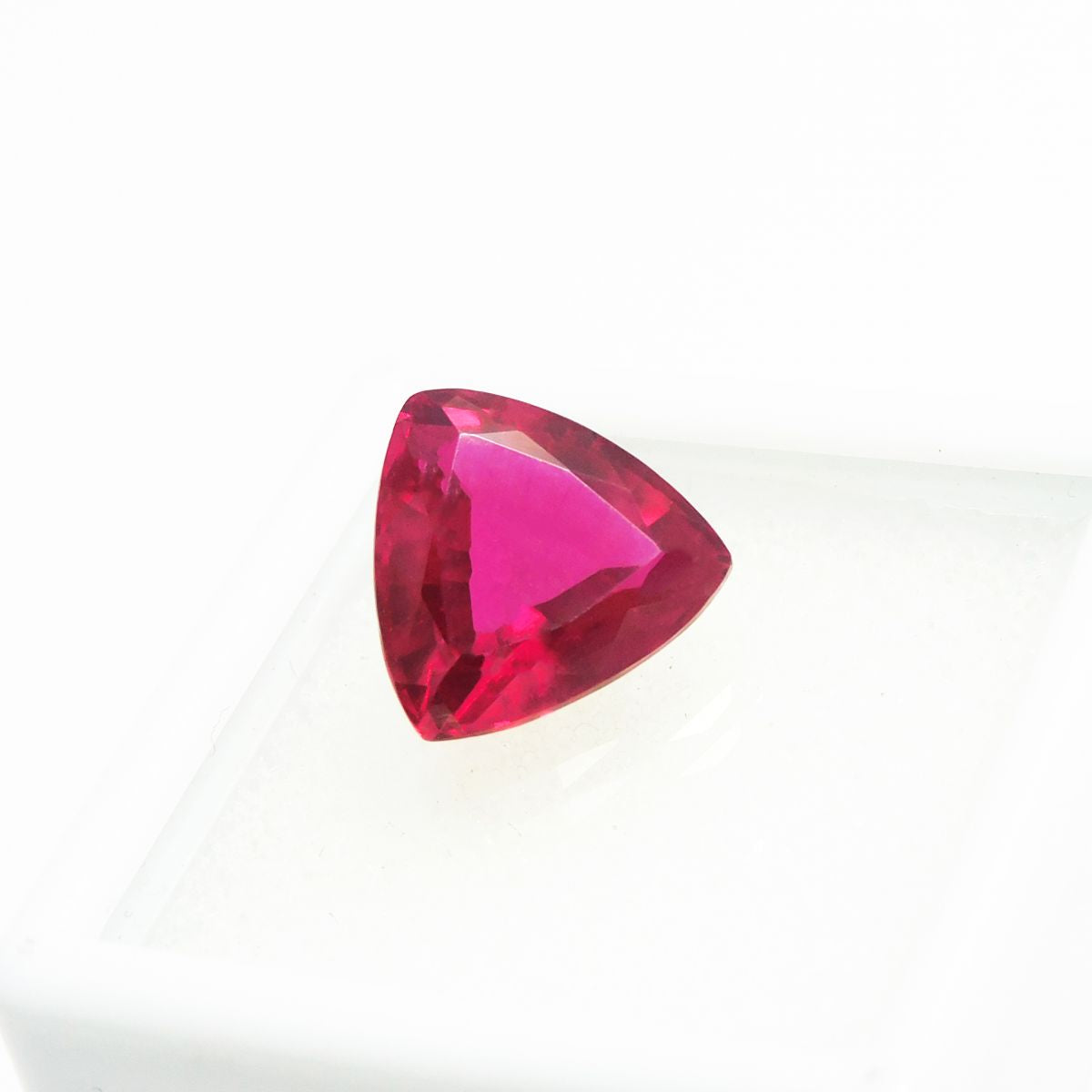 4.75 carat red ruby in trillion cut placed at center on white background – certified natural loose gemstone