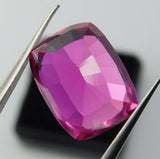 Pink ruby cushion cut gemstone held by gem tool – 11.66 carat natural ruby certified for rings