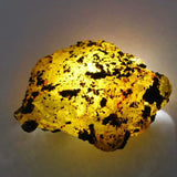 Yellow rock with black specks on a white background