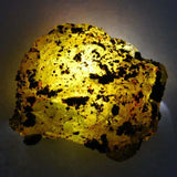 Lava rock with a glowing yellow light on a dark background