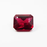 13.80 carat natural red ruby gemstone, emerald cut, placed in the center of a clean white background – certified and clarity enhanced