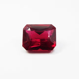 13.80 carat natural red ruby gemstone, emerald cut, placed in the center of a clean white background – certified and clarity enhanced