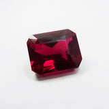 Top view of 13.80 ct red ruby emerald cut gemstone on white background – natural and eye clean