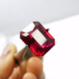13.80 carat natural ruby held by gemstone tweezer tool – emerald cut, clarity enhanced and certified