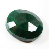 181.95 carat green Colombian emerald tilted slightly, displaying rich green color and natural inclusions