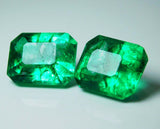 Pair of green emerald cut gemstones viewed from the side angle, highlighting thickness and transparency
