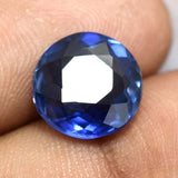 Round Cut Blue Tanzanite Gemstone Held Between Fingers - A++ Quality and Clarity Enhanced