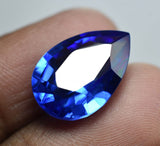 Pear Shaped Tanzanite Blue Gemstone Displayed Between Fingers - Natural and Certified Stone from Tanzania
