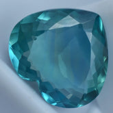 Faceted blue gemstone on a light gray background
