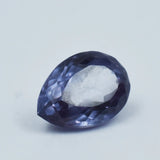 Faceted purple gemstone on a light gray background