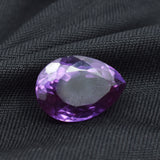 Color-change Alexandrite gemstone placed on black background showcasing brilliance and depth