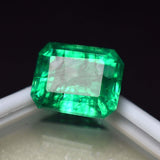 Emerald Cut Loose Gemstone 8.60 Ct positioned at white box edge with black background