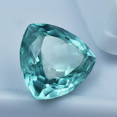 7.80 carat trillion-cut bluish-green sapphire, a certified loose gemstone.