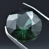 Certified 5.40ct natural deep green sapphire, a round-shaped loose gemstone.