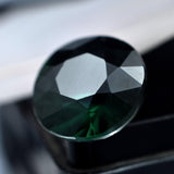 Natural certified sapphire, 5.40 carats, with a deep green color and a round shape