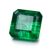 Faceted green gemstone on a white background