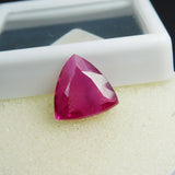 Trillion cut pink ruby loose gemstone on foam sheet, translucent clarity view