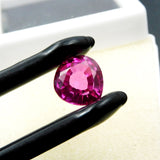 5.50 Ct pink ruby gemstone held by black jewel tool highlighting clarity and shape