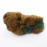 Mineral sample with brown and green hues on a white background