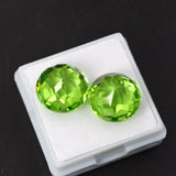 Pair of green gemstones in a white box on a black background