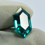 Fancy cut Green Garnet 10.35 Ct held vertically between two gloved fingers, certified and clarity enhanced