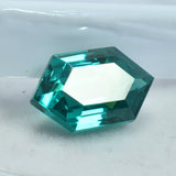 10.35 Ct Green Garnet lying horizontally on plain white background, fancy shape and eye-clean clarity