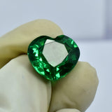 Certified heart-cut green garnet carefully held between two gloved fingers, emphasizing its defined curves and eye-clean finish