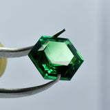 elegant fancy shape green garnet carefully held by precision jewel tool, ideal for unique jewelry designs