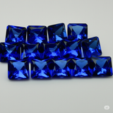 76 natural, certified, square-cut blue sapphire gemstones, each 5x5 mm in size.