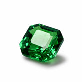 Faceted green gemstone on a white background