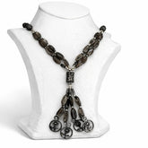 Necklace with dark beads and silver accents on a white mannequin bust