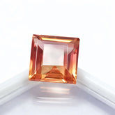 Square-cut orange gemstone on a white background